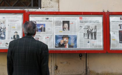 man reading newspaper in bulletin board